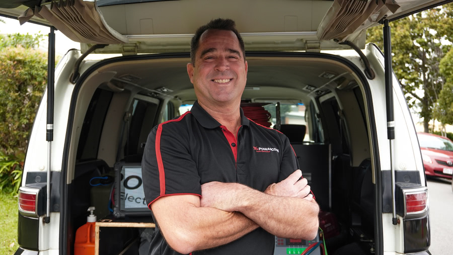 Peter smiling behind his van